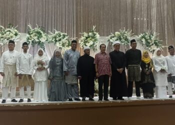 AHMAD MASLAN bersama-sama pasangan pengantin pada Majlis Walimatulurus Perdana anjuran Pejabat Agama Daerah Pontian di Dewan Serbaguna Benut, Pontian.