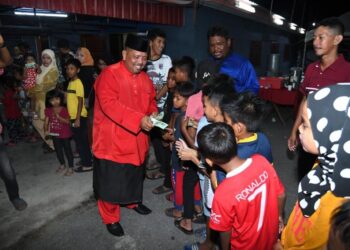 Abu Bakar Hamzah memberi duit raya kepada kanak-kanak pada majlis rumah terbuka Aidilfitri DUN Kuala Perlis semalam.-UTUSAN/IZLIZAN OTHMAN