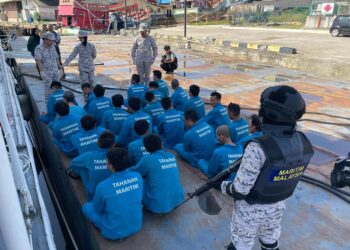 SYED Nor Aldi Syed Ab. Rahman (kiri) meneliti nelayan asing Vietnam yang dibawa ke Jeti  Tok Bali, Pasir Puteh, Kelantan, hari ini. UTUSAN/TOREK SULONG
