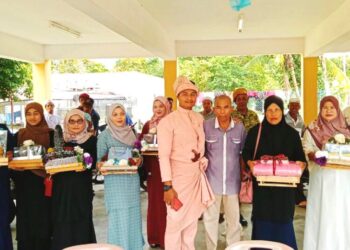 MUHAMAD Sharulnizam Kamarudin (tengah) terpaksa membuat persiapan perkahwinannya di PPS SK Gual To' Deh Rantau Panjang, Kelantan. -UTUSAN/ROHANA ISMAIL