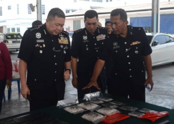 KHAW Kok Chin (kiri) melihat sebahagian dadah yang dirampas daripada seorang lelaki tempatan dalam sidang akhbar di IPK Pulau Pinang di George Town, hari ini. - Pix IQBAL HAMDAN