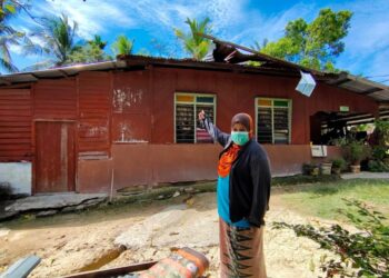 RUZILAH Abdul Rahman menunjukkan keadaan bumbung rumahnya yang rosak akibat kejadian angin ribut yang berlaku di Felda Pasir Besar, Gemas, Tampin, semalam.-UTUSAN/NOR AINNA HAMZAH.