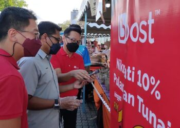 HAMDAN Hussin (tengah) melancarkan sistem pembayaran tanpa tunai dengan menggunakan aplikasi dompet digital Boost di bazar Ramadan dekat Taman Kerang di Kuantan, Pahang. - UTUSAN/ DIANA SURYA ABD WAHAB