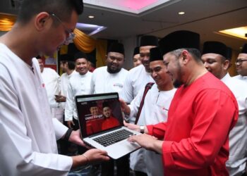 FATHUL Bari Mat Jahya (kanan) meninjau portal baharu yang ditubuhkan UMNO Bahagian Kangar dalam membantu menerima
aduan-aduan diutarakan rakyat pada Majlis Iftar Ramadan bersama kepemimpinan UMNO Bahagian Kangar di Hotel Regency, Kangar, Perlis semalam.-UTUSAN/IZLIZAN OTHMAN