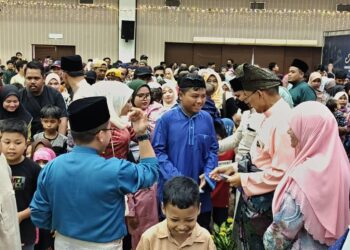 MOHD. Shukri Ramli (dua dari kanan) menyerahkan duit raya kepada kanak-kanak yang hadir ke Majlis Hari Raya Aidilfitri Menteri Besar dan Kerajaan Negeri Perlis yang berlangsung di Dewan 2020, Kangar, Perlis hari ini. -UTUSAN/ASYRAF MUHAMMAD