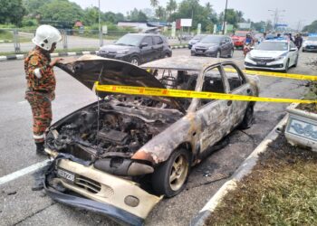 ANGGOTA JBPM Kelantan memeriksa keadaan kereta Proton Wira yang terbakar di Pasir Pekan, Tumpat, Kelantan hari ini/FOTO: ROHANA MOHD.NAWI
