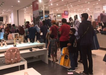 PELANGGAN beratur untuk membuat pembayaran di sebuah pusat membeli belah di Ipoh semalam. - UTUSAN/LIYANA RAMLI