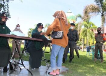 Pegawai polis Wilayatul Hisbah melakukan siasatan terhadap mereka yang ditahan kerana berada di luar rumah dengan mengenakan pakaian tidak mengikut syariat Islam di Aceh Barat. – AGENSI