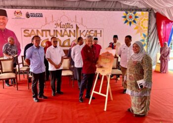 AHMAD Zahid Hamidi (empat dari kiri) menurunkan tandatangan sebagai gimik perasmian Majlis Sentuhan Kasih Ramadan di Pusat Kegiatan Masyarakat Simpang Empat, Kangar, Perlis, hari ini. -UTUSAN/ASYRAF MUHAMMAD