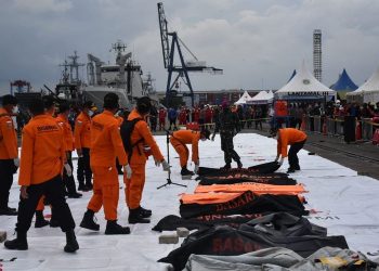 PASUKAN penyelamat menyerakan beg mayat yang mengandungi cebisan daging pebumpang dan serpihan bangkai pesawat Sriwijaya Air. - AGENSI