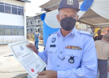 RAMLI Juri menunjukkan surat penghargaan yang diterimanya sempena Sambutan Hari Polis ke-215 Peringkat IPD Tampin, di sini hari ini.-UTUSAN/NOR AINNA HAMZAH