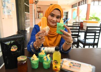 ATHIFAH Najwani Shahidan menunjukkan antara produk inovasi harumanis termasuk sambal dan aiskrim di Pusat Kecemerlangan Harumanis Bukit Bintang, Kangar, Perlis, semalam.- UTUSAN/IZLIZAN OTHMAN