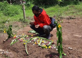 SALAH seorang keluarga mangsa menziarahi kubur mangsa di Tasikmalaya. - AGENSI