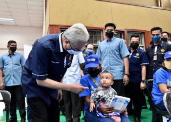 ISMAIL SABRI Yaakob menyantuni seorang ibu masyarakat Orang Asli bersama anaknya pada Program Bantuan Lesen Memandu Keluarga Malaysia di Kompleks Rakan Muda Bera di Bera pada 13 Mac 2022.