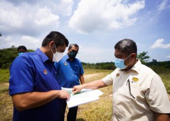 RADZI Jidin (kiri) diberikan taklimat oleh pihak JKR berkaitan pembinaan kolej tingkatan enam di Bukit Cina, Kok Lanas, Kelantan hari ini