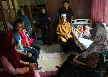 KAMALUDIN  Embong (tengah) bersama enam anaknya yang OKU dan dtemani Rozita Kamaludin (kiri) di rumah mereka di Kampung Keliyu, Serdang, Dungun, Terengganu. - UTUSAN/NIK NUR IZZATUL HAZWANI NIK ADNAN