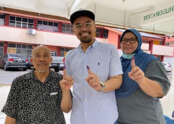 RADZI MANSOR (tengah) bersama bapanya, Mansor  Salim (kiri) serta kakak, Nor Hafiza  mengundi di SMK Sri Muar, Muar.