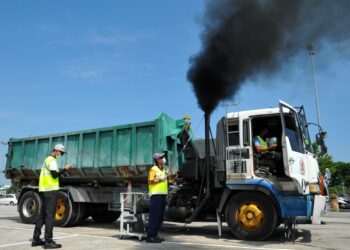 ANGGOTA penguatkuasa JAS melakukan pemeriksaan asap dalam Op Khas Bersepadu Kenderaan Perdagangan di Plaza Tol Skudai di Johor Bahru. -UTUSAN/RAJA JAAFAR ALI