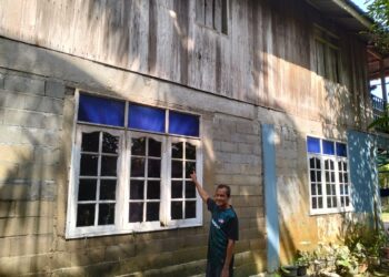 KAMARULZAMAN Hassan menunjukkan tingkap yang digunakan untuk keluar menyelamatkan diri ketika banjir Disember lalu di Kampung Baroh Pial Rantau Panjang. -UTUSAN/ROHANA ISMAIL