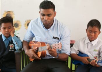 Samuel bersama murid  Orang Asli Sekolah Kebangsaan (SK) Runchang belajar bahasa Inggeris menggunakan alat muzik ukulele.