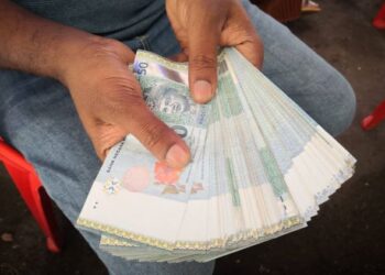 RAJ menunjukkan wang tunai yang dibawanya bagi membayar 40 saman trafik di kaunter sementara pembayaran saman di Taman Yayasan, Segamat, Johor.