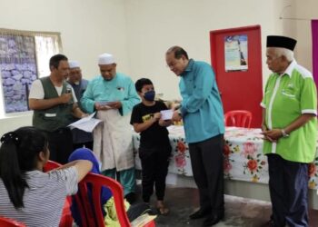 AHMAD Amzad Hashim (dua dari kanan) menyerahkan sumbangan kepada pelajar sempena Program Motivasi dan Anugerah Cemerlang untuk Pelajar Anak Orang Asal di Balai Raya Kampung Air Rengas, Johol, Kuala Pilah hari ini.-UTUSAN/NOR AINNA HAMZAH