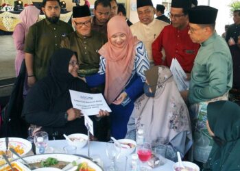 FADHLINA Sidek menyerahkan sumbangan dana Wakalaf Zakat YGMB kepada salah seorang guru pada majlis Rumah Terbuka Aidilfitri dan majlis penyerahan `mock cheque’ Program Wacana Ilmu `Apresiasi Pendidikan’ peringkat Pulau Pinang di George Town hari ini sambil diperhatikan Aminudin Adam (dua dari kiri) dan Wan Munadi Wan Mamat (kanan).