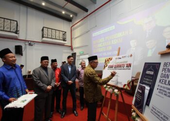 AWANG ADEK Hussin (kanan) menandatangani plak sempena perasmian Asnaf Qurratu' Ain@Pusat Islam USM di Hotel Imperial Heritage, Melaka semalam