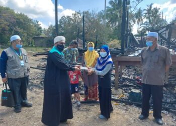 NASRUDIN Hassan menyampaikan sumbangan wang tunai Yadim kepada Pegawai Felda, Siti Zaharah Ismail mewakili keluarga mangsa rumah terbakar di Felda Jengka 8 di Maran, Pahang semalam.