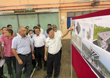 CHOW Kon Yeow meneliti pelan projek menaik taraf tapak penjaja Lebuh Kurau 5, di Seberang Perai, Pulau Pinang hari ini. - Pix: SITI NUR MAS ERAH AMRAN