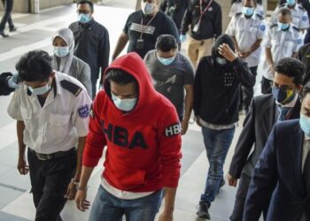 PEGAWAI JPN mengiringi lapan orang warganegara Filipina yang ditahan atas kesalahan menggunakan Kad Pengenalan palsu dan bekerja sebagai pengawal keselamatan untuk didakwa di Mahkamah Majistret Kuala Lumpur hari ini. - FOTO/FARIZ RUSADIO