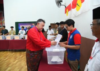 ROZABIL Abd. Rahman (kiri) sedang membuang undi sewaktu Mesyuarat Perwakilan UMNO Bahagian Arau 2023 di ILP, Perlis, hari ini. -UTUSAN/IZLIZAN OTHMAN