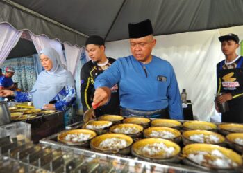 KAMARUL Zaman Mamat bersama isteri, Datin Suriati Muhamad membuat apam balik sempena Majlis Hari Raya Aidilfitri Kontinjen Johor di Johor Bahru di sini UTUSAN/RAJA JAAFAR ALI