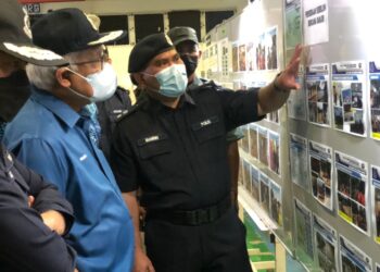 HAMZAH Zainudin mendengar taklimat yang disampaikan Bahrin Noh ketika meninjau keadaan banjir di Segamat, Johor.