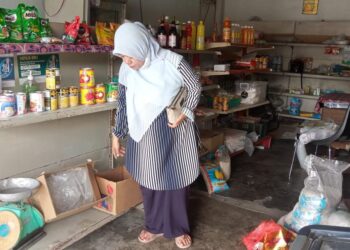 RAHIMAH Mahmud menunjukkan stok minyak masak peket sudah habis di kedai runcitnya di Kota Bharu semalam. – UTUSAN/ ROSLIZA MOHAMED