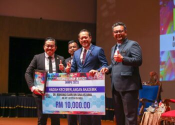 AHMAD Masrizal Muhammad (dua kanan) menyampaikan Hadiah Kecemerlangan Akademi kepada Dr. Mohamad Sabri Sinal selepas merasmikan HIMPU 2022 UUM di Sintok, Kubang Pasu.- UTUSAN/ SHAHIR NOORDIN