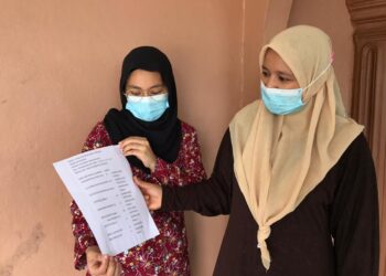 AINA NURAIN bersama ibunya Siti Azehan Jusoh melihat salinan keputusan SPM di rumahnya di Kampung Huda, Kota Bharu. - UTUSAN/ROHANA MOHD. NAWI