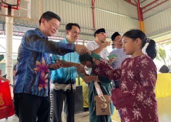 CHOW Kon Yeow memberi duit raya kepada kanak-kanak pada Majlis Santai Aidilfitri di Taman Tangling, Batu Kawan, Pulau Pinang hari ini. - Pix: SITI NUR MAS ERAH AMRAN