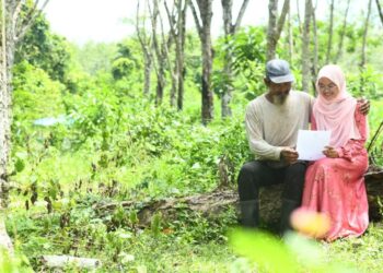 NUR Alia Maisarah menunjukkan keputusan 9A SPM yang diperolehi kepada ayahnya, Abdullah Ismail,54, yang sedang menoreh getah di sebuah kebun getah di Kampung Kubang Perun, Chuping, Padang Besar, Perlis semalam.-UTUSAN/IZLIZAN OTHMAN