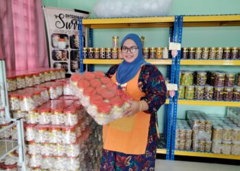 NORSAFARINA Ahmad menunjukkan kuih bangkit cheese yang telah siap untuk dipasarkan di bengkel perusahaannya di Kampung Pulai Sebatang, Pontian.