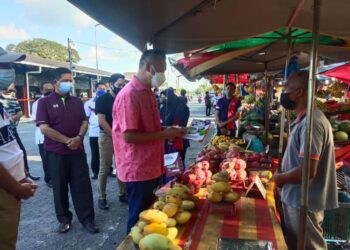 MUHAMAD SADE MOHAMAD AMIN bertemu peniaga bagi berkongsi maklumat mengenai AADK di pekan Simpang Empat, Kangar, Perlis hari ini.- UTUSAN/SYED AZLAN SAYID HIZAR