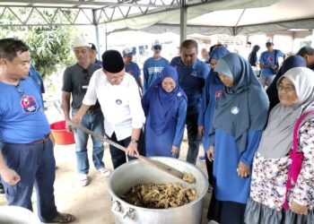 HASNI MOHAMMAD melihat ayam masak ungkep pada Majlis Kenduri Sekampung di Kampung Parit Salman, Simpang Renggam.