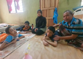 JUMAHIR Mahsun dan anaknya, Nor Hanisa bersama tiga daripada empat anak lelakinya yang OKU di rumah mereka di Felda Kerteh 6, Dungun, Terengganu. – UTUSAN/NIK NUR IZZATUL HAZWANI NIK ADNAN