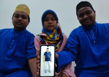 HARITS Musyiri (kiri), 24, Nur Sufiah Musyiri (tengah), 12, dan Haziq Musyiri (kanan), 19, menunjukkan gambar arwah bapa mereka yang terbabit dalam kemalangan di jambatan kedua Pulau Pinang semalam ketika ditemui di rumah mereka di Nibong Tebal hari ini. - Pic IQBAL HAMDAN