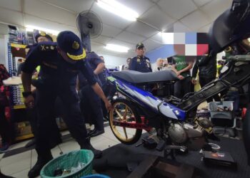 ANGGOTA JPJ memeriksa motosikal di sebuah bengkel yang menjadi tumpuan 'mat rempit' dalam Ops Bengkel di sekitar George Town, Pulau Pinang hari ini. - Pix: IQBAL HAMDAN