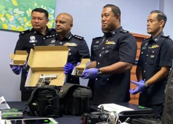 A A ANBALAGAN (dua dari kiri) menunjukkan pistol yang dirampas dipercayai digunakan lelaki untuk mengugut peniaga di sekitar daerah tersebut.