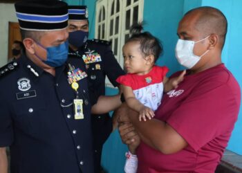 AIDI Ismail (kiri) menyantuni Nur Asyfa Alisyah, anak Allahyarham Nurhalim Tumiran yang didukung oleh bapa saudaranya, Romi Tumiran di Felda Bukit Damar, Lanchang di Temerloh, Pahang. - UTUSAN/SALEHUDIN MAT RASAD