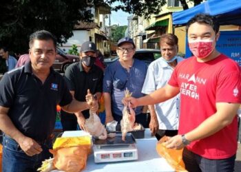 KERK Chee Yee (kanan) dan Ketua PKR Cabang Hang Tuah Jaya, Mohd. Rafee Ibrahim menunjukkan ayam yang dijual pada program jualan ayam murah di Batu Berendam, Melaka. UTUSAN/HADI AB. MANAP