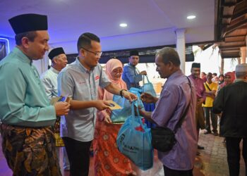 NIK Nazmi Nik Ahmad (dua, kiri) menyampaikan sumbangan kepada golongan asnaf pada Majlis Iftar Ramadan di Kuala Terengganu, malam ini. - UTUSAN/PUQTRA HAIRRY ROSLI