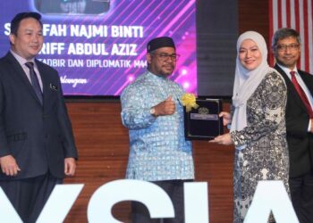 Mohd. Khairuddin Aman Razali (tengah) menyampaikan Anugerah Perkhidmatan Cemerlang kepada Sharifah Najmi Shariff Abdul Aziz pada Majlis Perhimpunan Bulanan Kementerian Perusahaan Perladangan dan Komoditi diPutrajaya, semalam. – utusan/FAISOL MUSTAFA